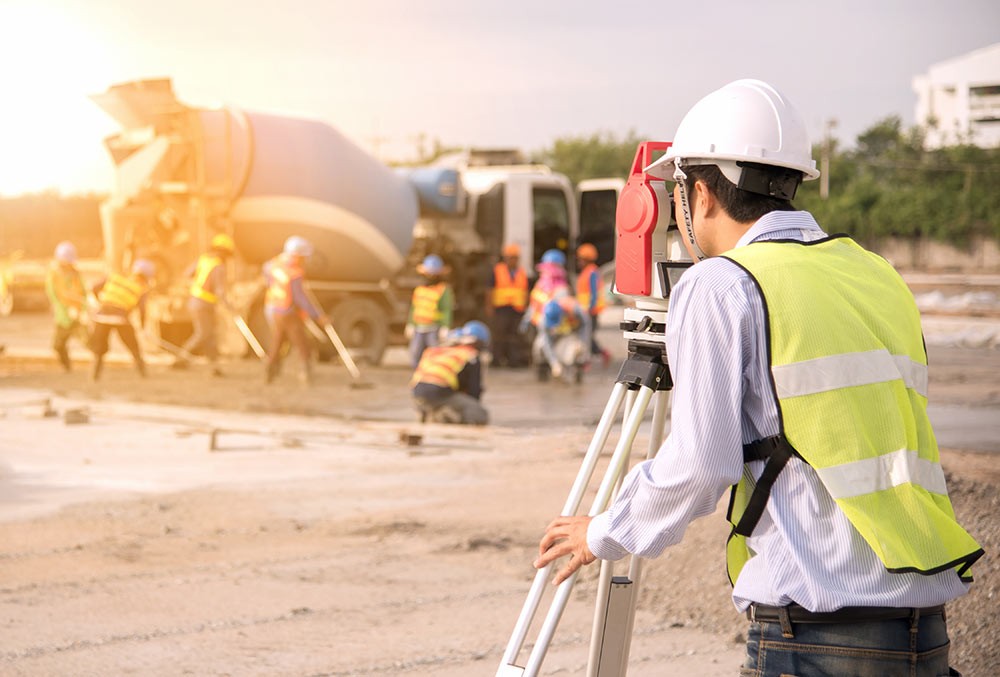 Surveyor engineers using an altometer at Construction Site.